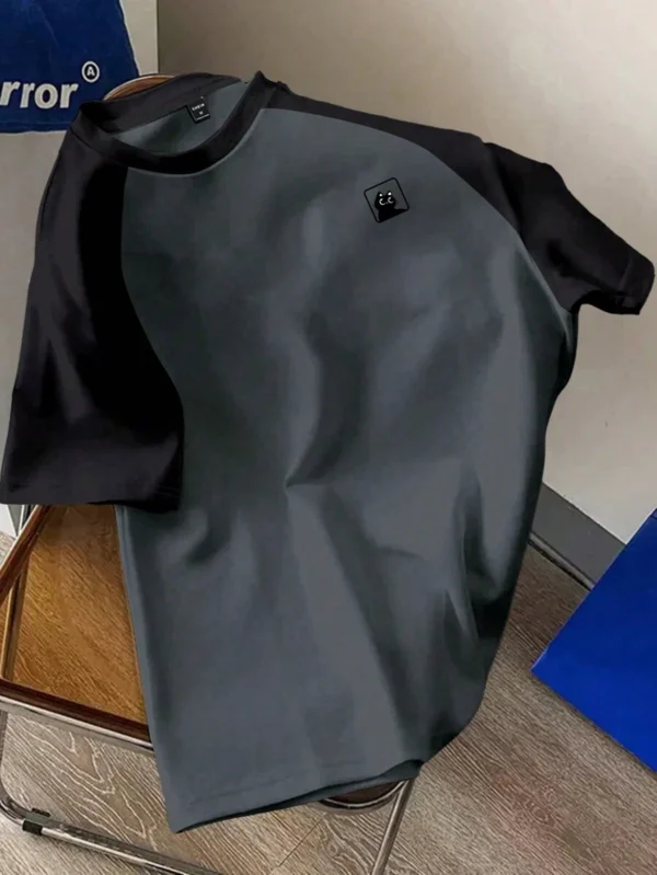 Camiseta de manga corta tipo raglan con parches en negro y blanco y gráfico