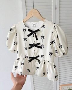 Blusa elegante con mangas abullonadas y decoración de lazo
